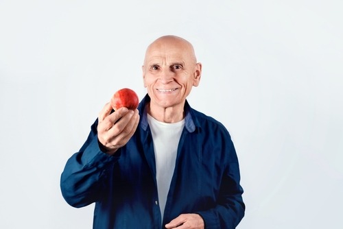 man with dentures about to eat an apple